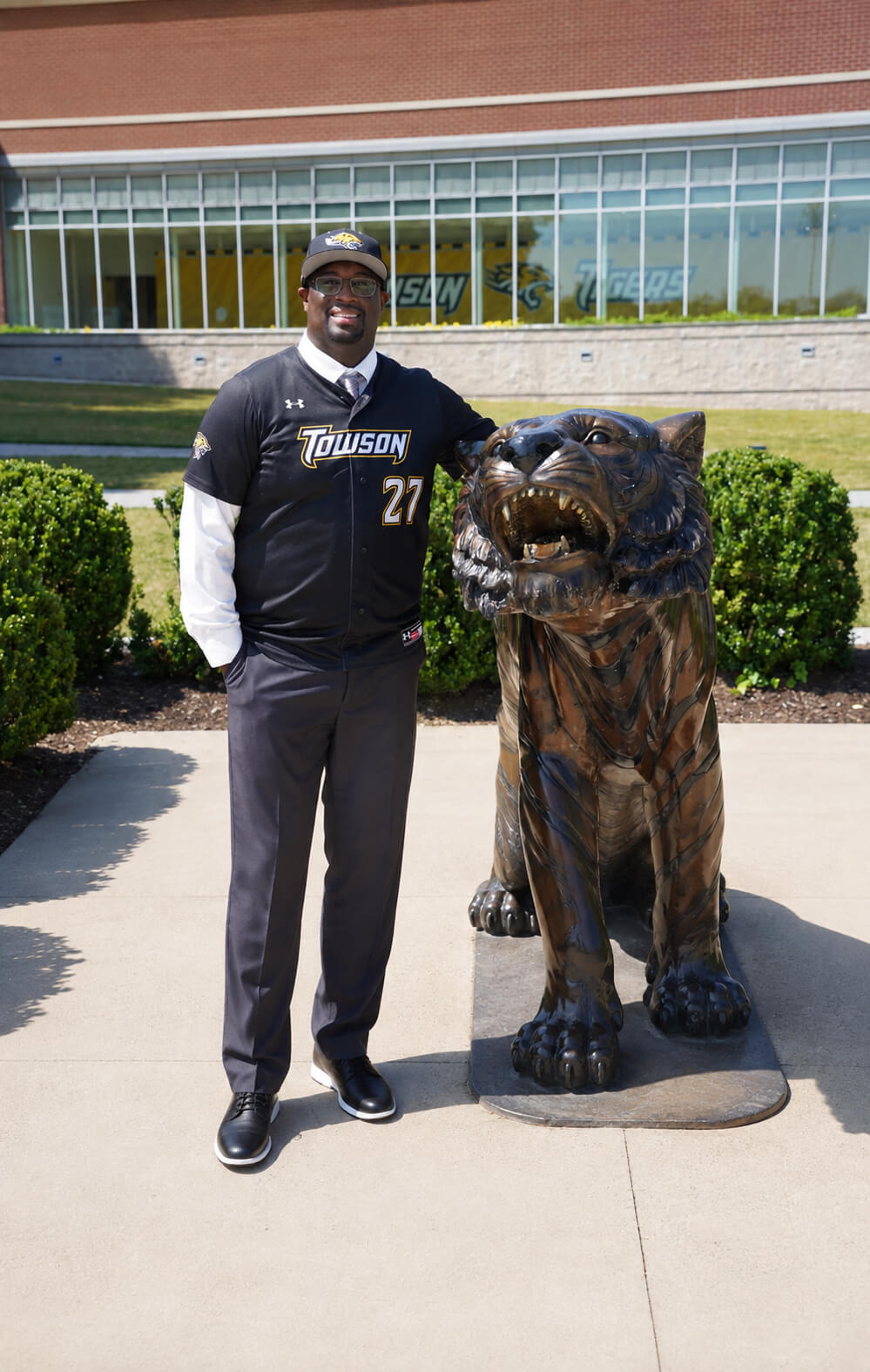 This is an image of Coach Daniel Stockdale with the Tiger statue on campus at Towson University, Towson, Maryland.